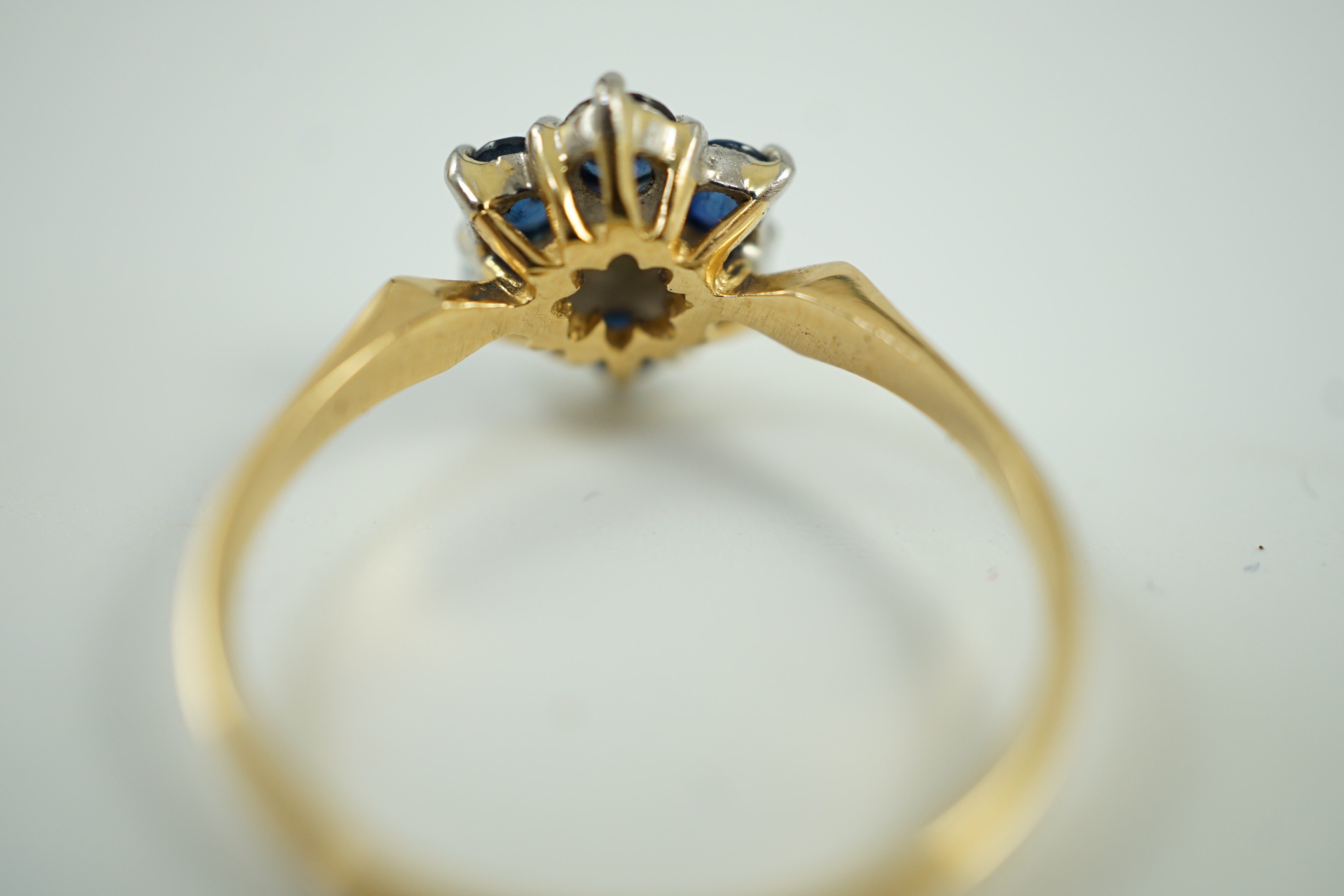 A modern 18ct gold, sapphire and diamond cluster set ring, size Q, gross weight 2.9 grams.